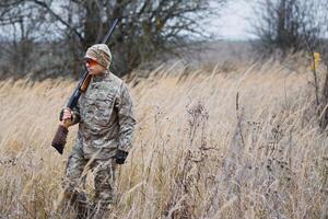 cazador en uniforme con un caza rifle. caza concepto. foto