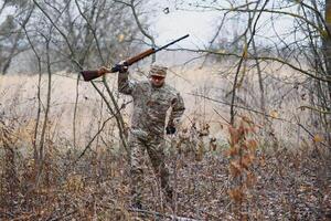 cazador en uniforme con un caza rifle. caza concepto. foto