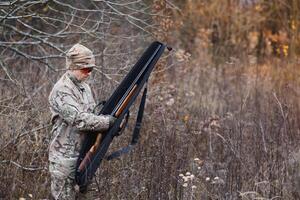 Hunter in uniform with a hunting rifle. Hunting Concept. photo