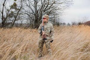 cazador en uniforme con un caza rifle. caza concepto foto