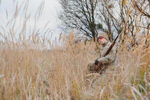 Hunter in uniform with a hunting rifle. Hunting Concept. photo