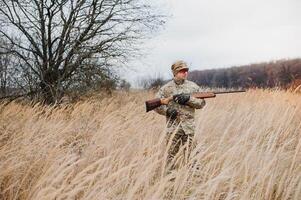 cazador en uniforme con un caza rifle. caza concepto foto