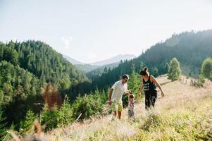 joven mamá con bebé chico de viaje. madre en excursionismo aventuras con niño, familia viaje en montañas. nacional parque. caminata con niños. activo verano vacaciones. ojo de pez lente. foto