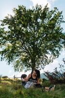 joven mamá con bebé chico de viaje. madre en excursionismo aventuras con niño, familia viaje en montañas. nacional parque. caminata con niños. activo verano vacaciones. ojo de pez lente. foto