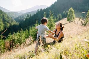 Young mom with baby boy travelling. Mother on hiking adventure with child, family trip in mountains. National Park. Hike with children. Active summer holidays. Fisheye lens. photo