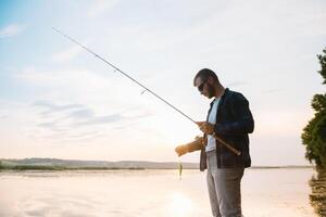 joven hombre pescar a brumoso amanecer foto