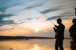 pesca. hilado a puesta de sol. silueta de un pescador foto