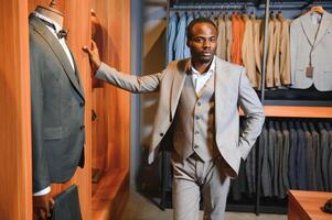 African Businessman in classic suit against row of suits in shop photo