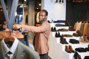 A handsome young african gentleman buying an elegant suit photo