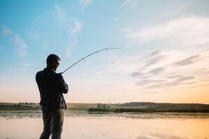 pesca. hilado a puesta de sol. silueta de un pescador. foto