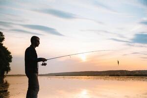 joven hombre pescar a brumoso amanecer. foto