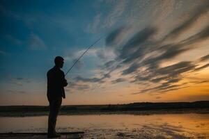 pesca. hilado a puesta de sol. silueta de un pescador. foto