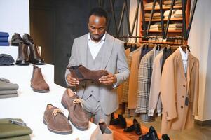 Young african man shopping in clothing store photo