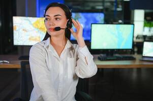 simpático sonriente mujer llamada centrar operador con auriculares utilizando computadora a oficina foto