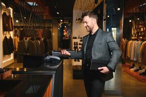 Joyful african american man carrying shopping bags in clothing store. Fashion boutique photo