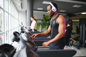 hombre corriendo en cinta de correr en el gimnasio foto