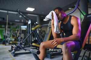 Thoughtful young man with towel in health club photo