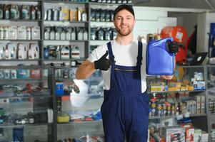 seller man with canister of motor oil in auto store photo