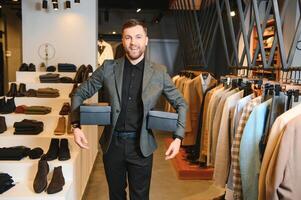 Joyful african american man carrying shopping bags in clothing store. Fashion boutique photo