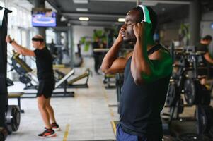 africano americano hombre escuchando motivacional música terminado auriculares mejorando calidad de rutina de ejercicio foto