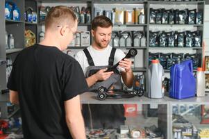 A customer speaks with a consultant at an auto parts store photo