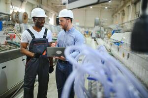 An engineer communicates with a worker on a production line photo