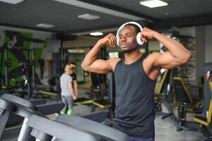 africano americano hombre escuchando motivacional música terminado auriculares mejorando calidad de rutina de ejercicio foto