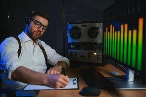 A male spy listens and records conversations on a reel-to-reel tape recorder photo