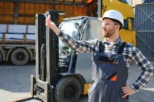 Portrait of professional forklift driver in factory's warehouse photo