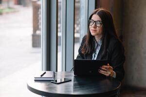 joven mujer de negocios utilizando tableta computadora. mujer en un café descanso foto
