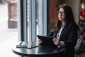 joven mujer de negocios utilizando tableta computadora. mujer en un café descanso foto