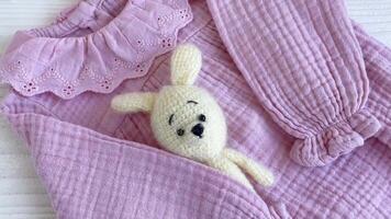 Pink bodysuit with toy knitted toy, socks and headband. video