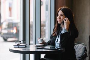 joven mujer de negocios hablando en el teléfono en café tienda. foto