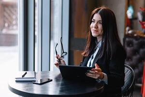 joven mujer de negocios utilizando tableta computadora en café tienda. foto