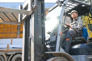 Portrait of heavy industry forklift driver giving thumbs up and smiling photo