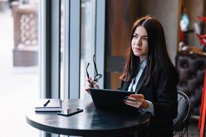 joven mujer de negocios utilizando tableta computadora en café tienda. foto