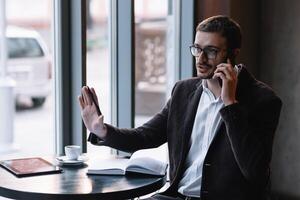 Handsome businessman talking on the phone in a cafe. photo