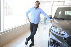 Handsome man is standing near his new car and smiling photo