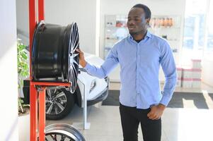 An African man buys car rims in an auto parts store photo