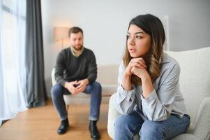 An agitated and upset husband shouts and looks at his wife, a quarrel between spouses. Family misunderstanding, quarrel photo