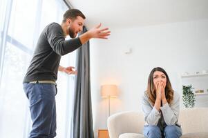 un agitado y trastornado marido gritos y mira a su esposa, un pelea Entre esposos. familia malentendido, pelea foto