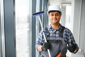 masculino portero limpieza ventana en oficina foto