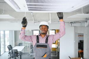 african Male Technician Repairing Air Conditioner. photo