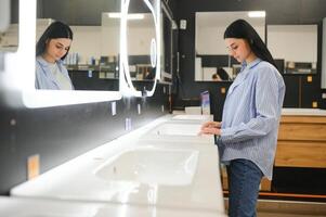 Woman chooses a mirror at home in a store photo