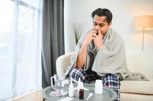 un enfermo indio es tratado a hogar y usos un nasal rociar. cuidado de la salud concepto foto