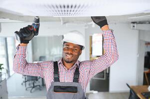africano masculino técnico reparando aire acondicionador. foto