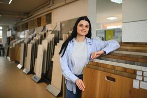 Young woman choosing laminate floor for home renovation photo