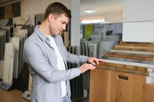 Choosing parquet. Man is in the store of goods for the home photo