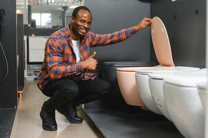 African american Man choosing home toilet in store photo