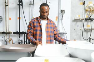 africano americano a el edificio mercado mirando para lavabo dentro su baño foto